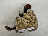 a gold figurine sitting on a white surface