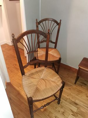 two chairs in the corner of a room next to a table