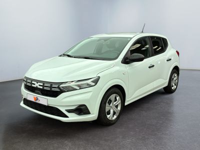 Une voiture blanche est garée dans une pièce au sol noir.
