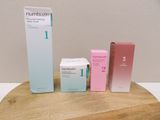 trois boîtes posées sur une table en bois, avec une boîte de dentifrice