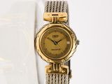une photo d'une montre-bracelet pour femme posée sur une surface blanche