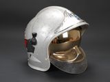 an old silver helmet on a black background with a red light on it
