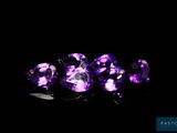 a group of purple gems sitting on top of a black surface