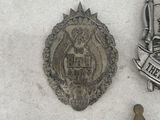 two badges and a star sit on a white surface
