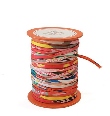 an orange spool with a spool of colorful ribbons on it