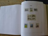 un livre ouvert avec des timbres, posé sur une table