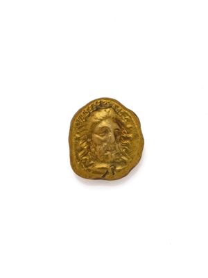 gros plan d'une pièce d'or sur une surface blanche