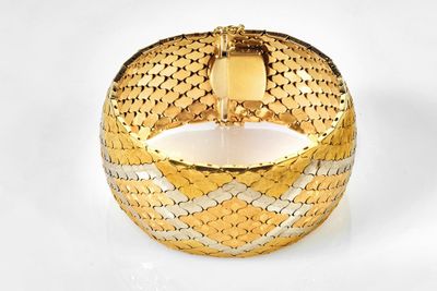 an image of a close up of a gold bracelet on a white surface