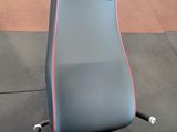 a close up of a bench in a gym with other equipment in the background