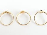 three gold rings on a white surface with a white background