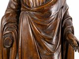 wooden statue of a man in a robe holding a book