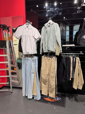 beaucoup de vêtements suspendus à une étagère dans un magasin