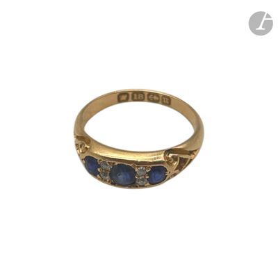 Gros plan sur une bague en or ornée de pierres bleues