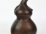 un vase brun posé sur une surface blanche