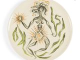 a plate with a drawing of a woman holding a flower
