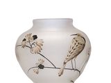 a white vase with a bird on it on a white surface