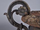 an old metal bowl with a handle on a table