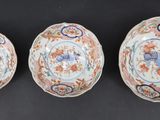 three chinese porcelain bowls with floral designs on them on a black surface