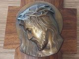 a bronze horse head on a wooden plaque on a desk