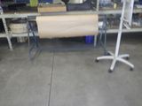 une table sur laquelle est posé un rouleau de papier, dans un garage