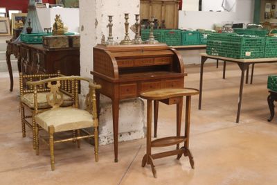 de nombreuses chaises et tables dans une pièce où il y a beaucoup de cartons par terre