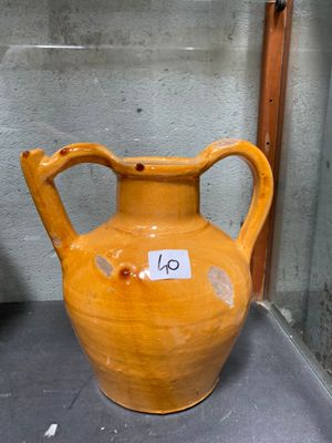 un vase jaune posé sur une table, avec une étiquette de prix dessus
