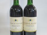 two bottles of red wine sitting next to each other on a table