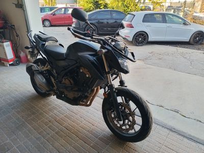 a black motorcycle parked in a garage next to a white car