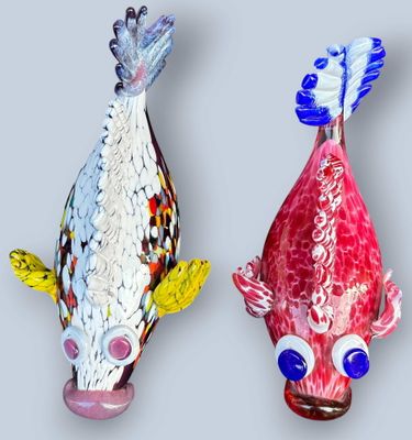 deux sculptures de poissons colorés sur une surface grise