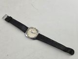 a close up of a watch on a white surface with a black strap