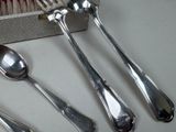four silver spoons and two silver spoons on a table
