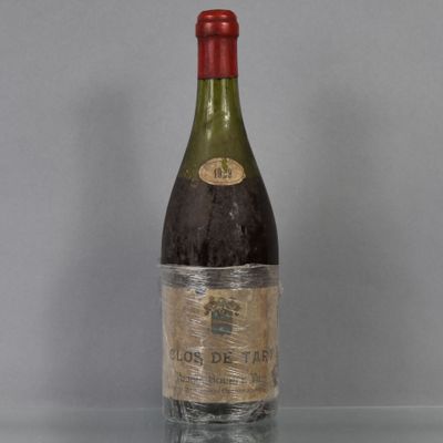 an old bottle of wine sitting on top of a glass table