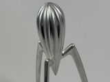 a close up of a metal juicer on a white surface