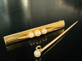 deux épingles à cheveux dorées ornées de perles, sur un fond noir