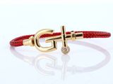 un bracelet en cuir rouge orné d'une ancre dorée