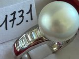 une bague en perle blanche dans un coffret rouge avec une étiquette de prix