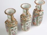 three vases are sitting side by side on a white surface