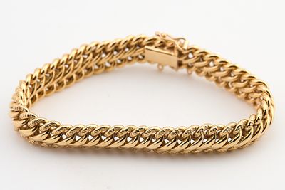 un bracelet à chaîne en or avec un fermoir sur fond blanc