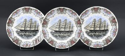 trois assiettes ornées d'une illustration représentant un bateau sur fond noir