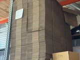 une grande pile de cartons posée sur une étagère dans un entrepôt