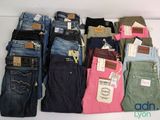 plein de jeans de différentes couleurs posés sur une table