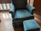 un fauteuil bleu et un pouf dans un salon équipé d'une porte-fenêtre coulissante