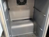 a small refrigerator that is open on a wooden floor