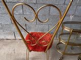 une chaise avec une assise rouge et une chaise dorée avec un coussin rouge