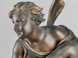 an antique bronze statue of a boy with a bird on his back