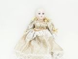 une image représentant une poupée aux cheveux blonds et vêtue d'une robe blanche