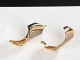 pair of white glass and gold plated cufflinks on a white plate
