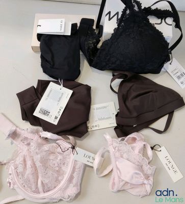 Plusieurs soutiens-gorge et sous-vêtements sont posés sur une table, encore étiquetés.