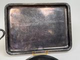 a silver tray and a silver plate on a white table