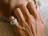 a woman that is wearing a ring on her neck